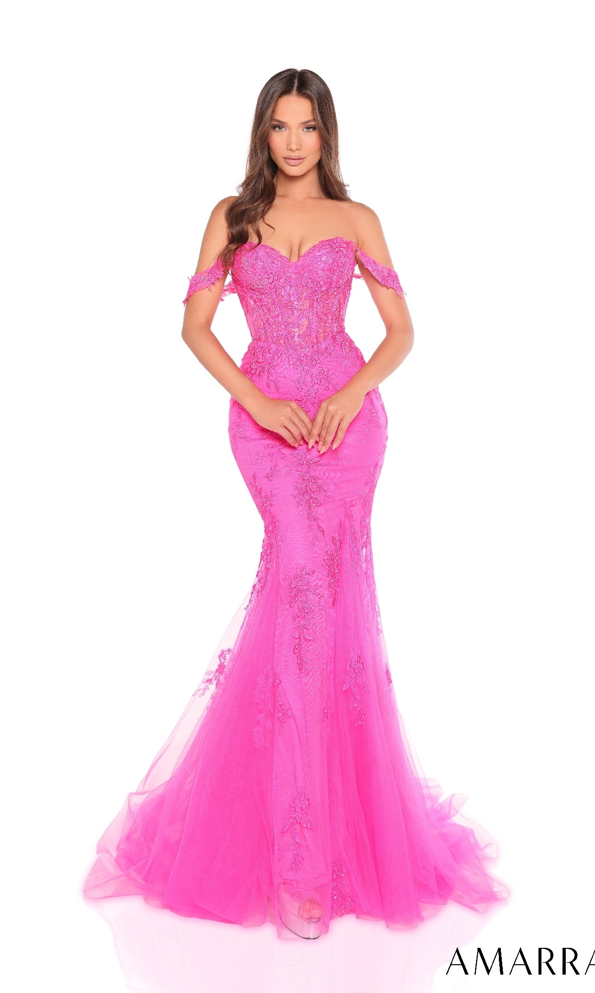 A woman wearing the Amarra 88224 long prom dress, featuring bright pink glitter tulle, off-the-shoulder design, lace detailing, and a corset bodice, stands against a white background.